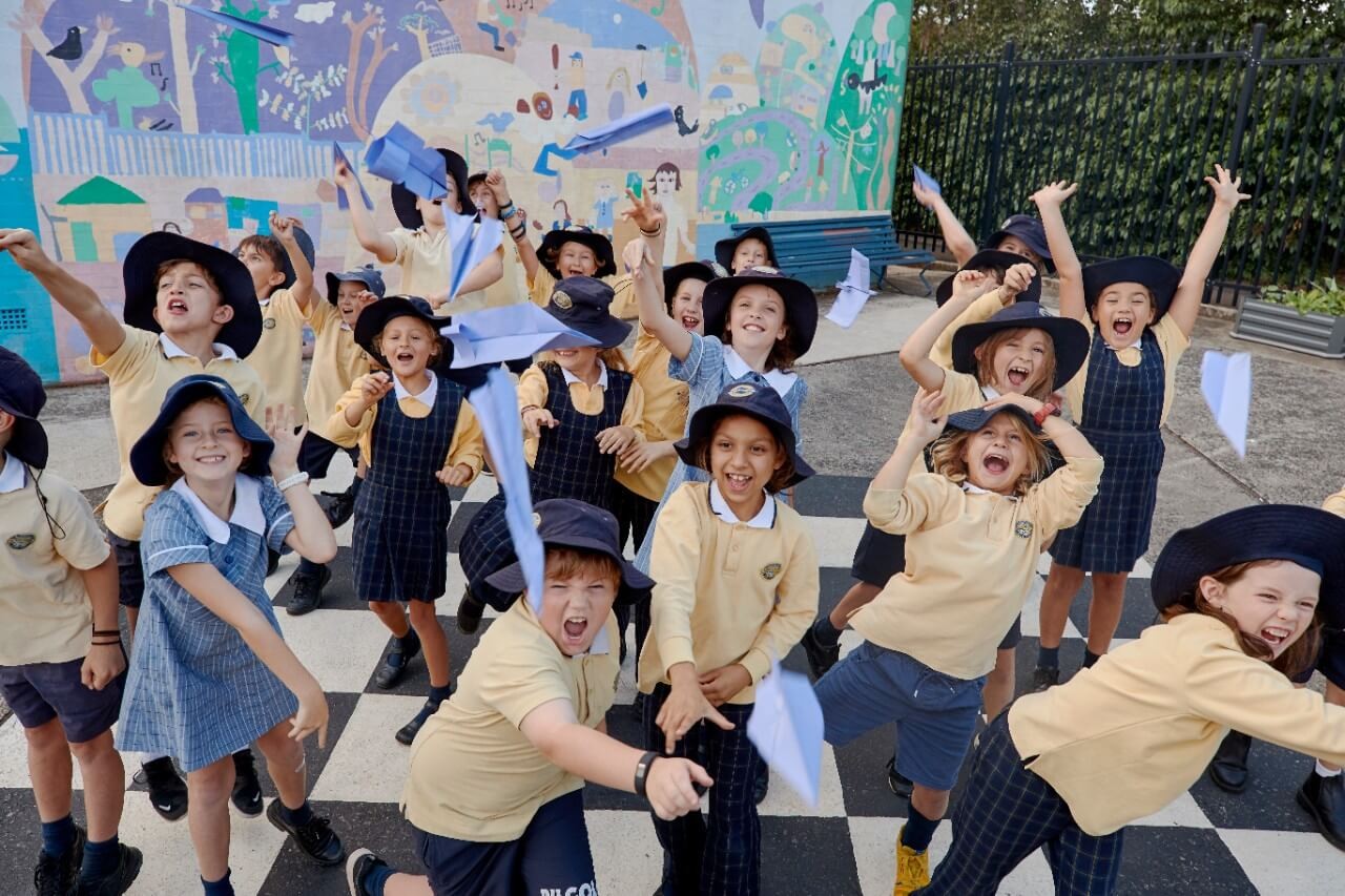EdWeek2023SWS Primary school students playing with paper planes on their school playground.